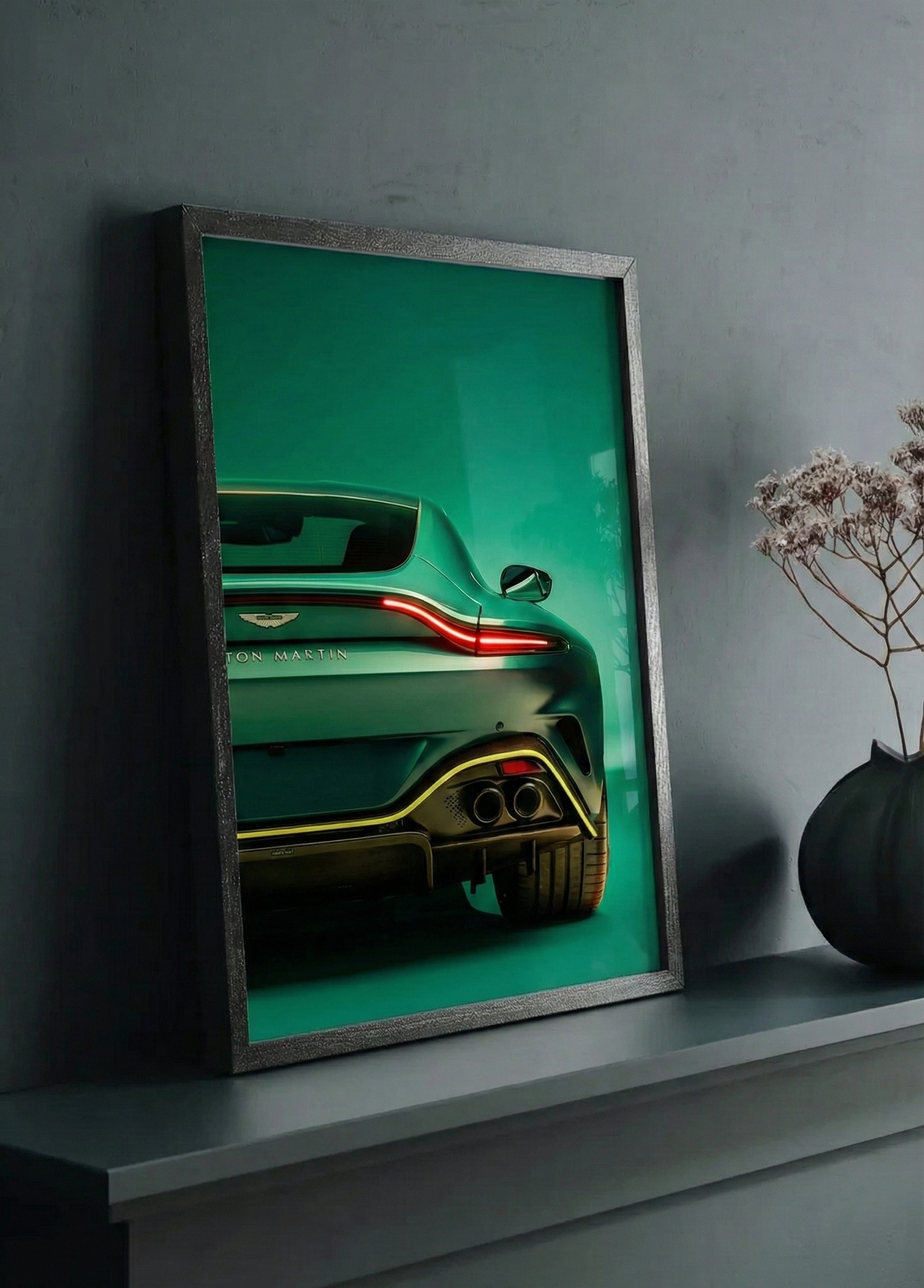 Framed artwork of a green supercar on a dark surface with a dark background